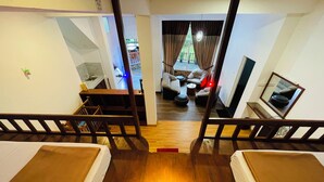 Une chambre avec deux lits, un bureau, une chaise, un canapé et une télévision.
