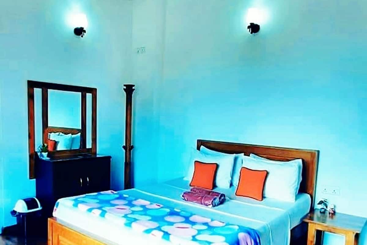 Une chambre à coucher avec un lit en bois, une table de chevet, un miroir et un ventilateur de plafond.