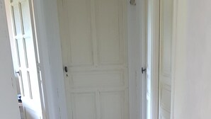 Ein Flur mit Holzdielen und weißen Türen.
