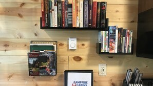 A kitchen area with a granite countertop, a coffee maker, a knife block, and a welcome guide for Campfire Cabins.