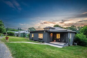 A modern two-story house with a well-maintained lawn and a driveway leading to the entrance. - Downtown Fayetteville Home | Walk to Dinner | Fire Pit, Sleeps 8 (Fayetteville)