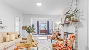 Ein Wohnzimmer mit einer Couch, einem Sessel, einem Couchtisch und einem Kamin.