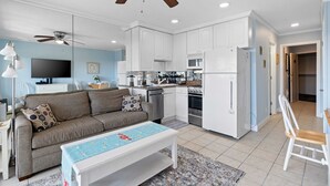 A modern kitchen with white cabinets, a microwave, and a refrigerator. - Beautiful Ocean View - Walk to Coligny (Hilton Head Island)
