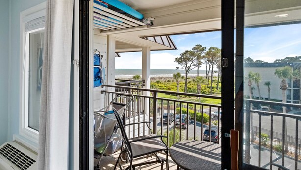 A balcony with a view of the ocean, a chair, and a table. - Beautiful Ocean View - Walk to Coligny (Hilton Head Island)