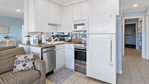 A modern kitchen with white cabinets, a built-in oven, a microwave, and a refrigerator. - Beautiful Ocean View - Walk to Coligny (Hilton Head Island)