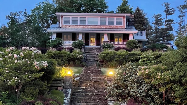Una casa grande con una escalera de piedra que lleva a un porche.