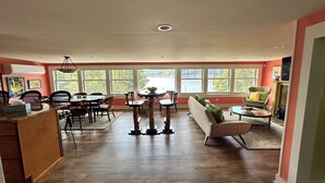 Amplia sala de estar con una mesa de comedor, sillas, un sofá y una chimenea.