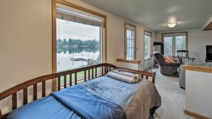 A bedroom with a large window, a bed, a desk, and a chair. - Lakefront Home w/ Seasonal Dock - 2 Mi to Skiing! (Wautoma)