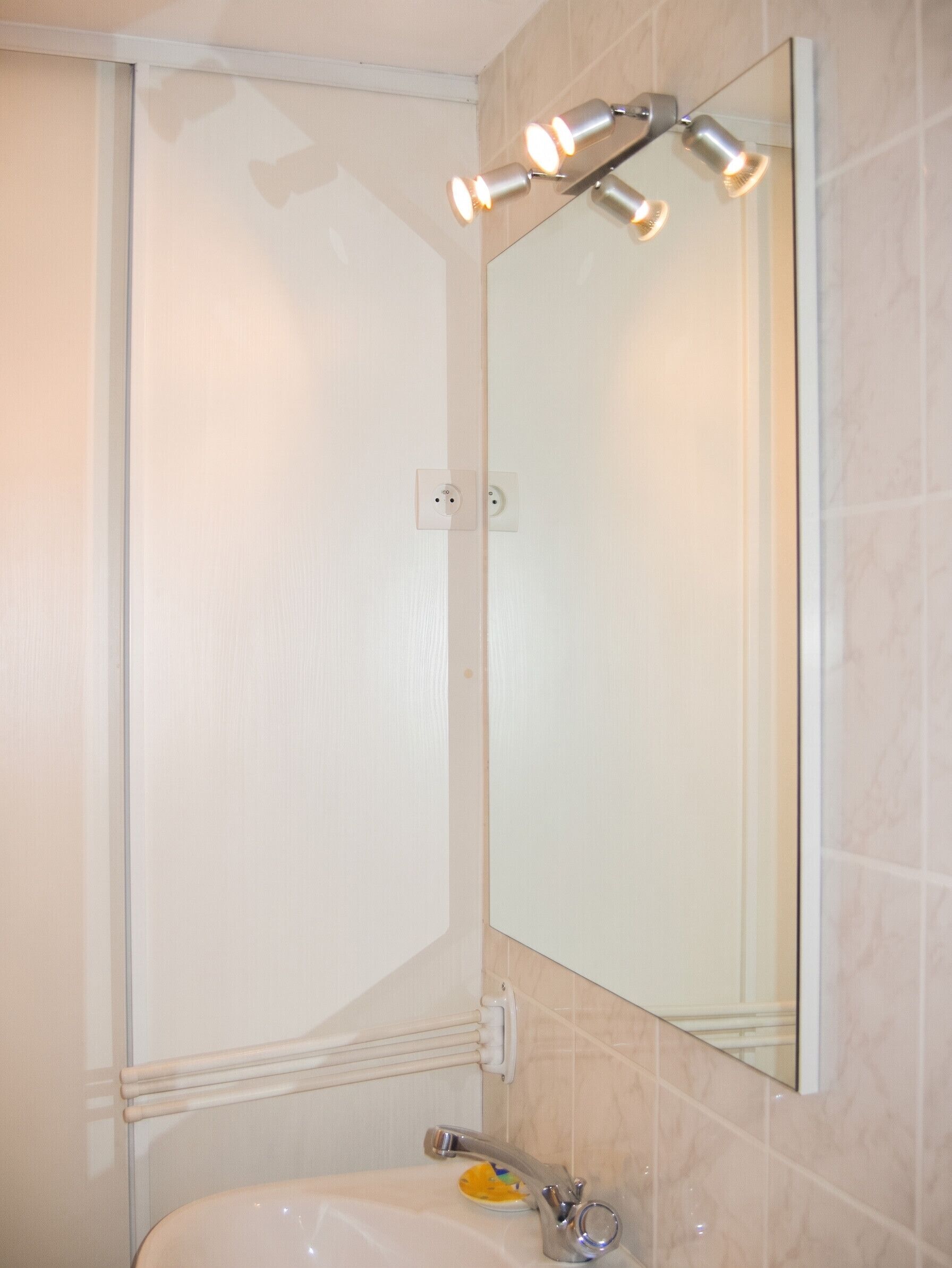 Un baño con ducha, lavabo y espejo.