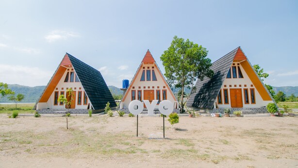 Tres casas triangulares con un letrero central que dice "OYO".