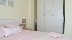 A bedroom with a bed, a nightstand, a wardrobe, and a map on the wall.