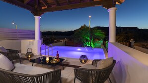 Área externa coberta com piscina, mobiliário de vime e iluminação ambiente.