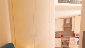 A living room with a sofa, a television, and a kitchen in the background. - FRIDDA HOUSE ATOCHA STATION MADRID (Madrid)