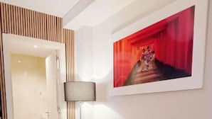 A modern living room with a blue sofa, two patterned throw pillows, a floor lamp, and a framed artwork on the wall. - FRIDDA HOUSE ATOCHA STATION MADRID (Madrid)