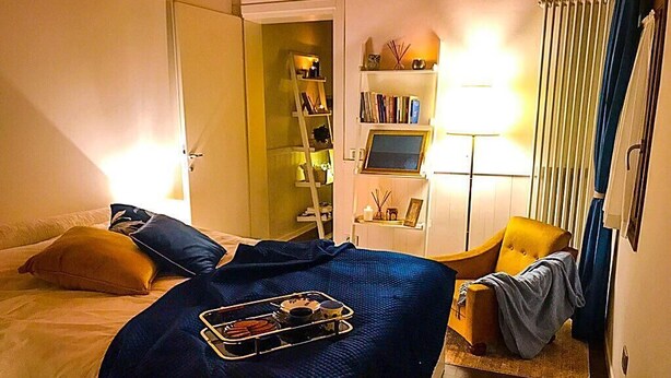 A hotel room with a bed, a chair, a desk with a computer, and a bookshelf. - Elegant independent apartment in the historic center (Vicenza)