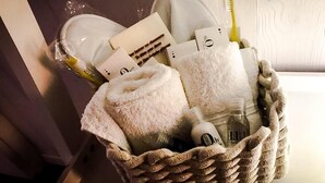 A wicker basket containing toiletries, including a towel, toothbrush, and bottles. - Elegant independent apartment in the historic center (Vicenza)
