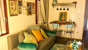 A cozy living room with a sofa, a small table, and a decorative glass table with a candle. - Elegant independent apartment in the historic center (Vicenza)