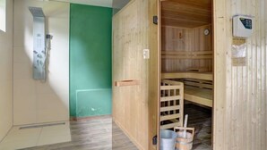 A sauna room with a wooden door, a control panel, and a small bucket. - An der Dorfkirche by Interhome (Hehlen)