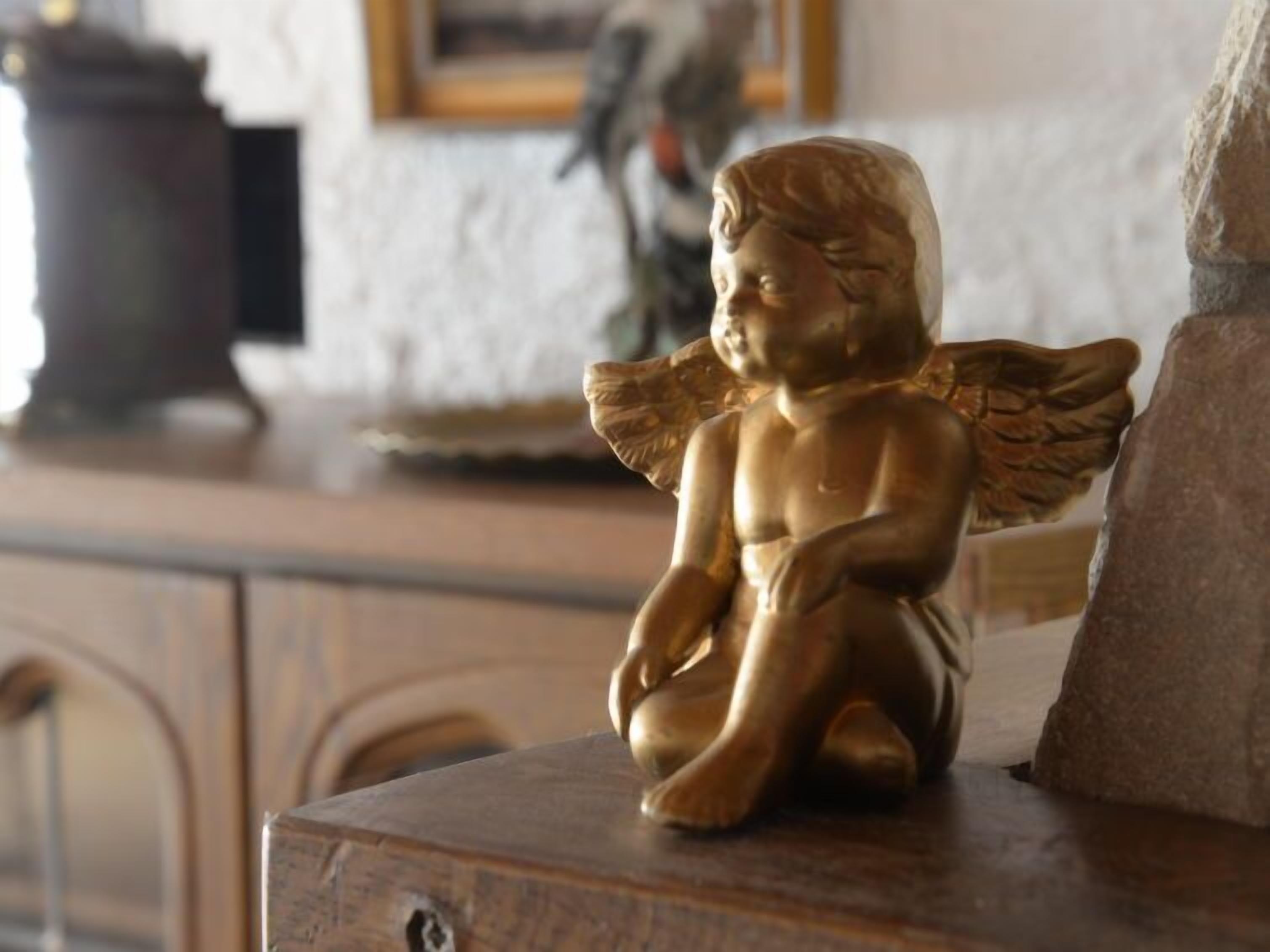 Una estatua dorada de un ángel sobre una superficie de madera.