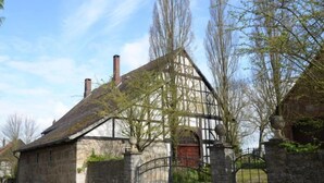 A traditional half-timbered house with a stone wall and a metal gate. - An der Dorfkirche by Interhome (Hehlen)
