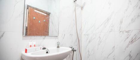 A bathroom with a white sink, a mirror, and a shower.