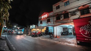 Un edificio con un cartello 'OYO' ben visibile, un ingresso coperto e diverse motociclette parcheggiate.
