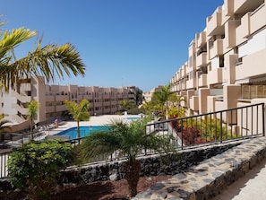 A resort with a pool, palm trees, and modern buildings. - ☀️ Top Rated Apartment. Huge Sunny Terrace. Heated Pool. Parking. Wifi. (Adeje)