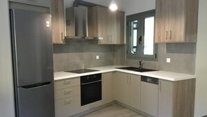 Una cocina moderna con un refrigerador de acero inoxidable, un lavavajillas y un lavamanos doble.
