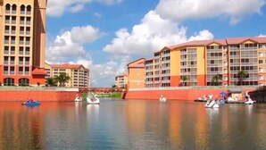 Hotel na orla com vários edifícios, um rio calmo e barcos.