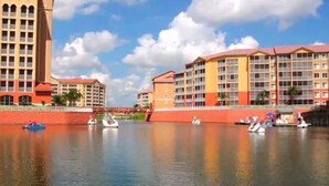 Een hotel aan het water met meerdere gebouwen, een rustige rivier en boten.