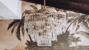 A bedroom with a bed, a chandelier, and a mural of palm trees. - Ocho Suites & Kitchen (Palma de Mallorca)