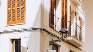 A building facade with a sign reading "ACHO" and a potted plant on the ground. - Ocho Suites & Kitchen (Palma de Mallorca)