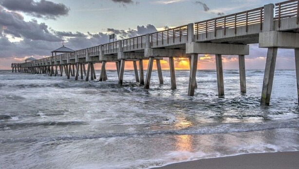 A pier extending into the ocean with a gazebo at the end.
