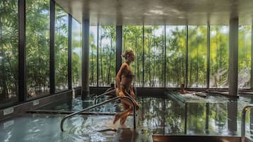 Swimmers can enjoy a refreshing dip in the pool surrounded by lush greenery.