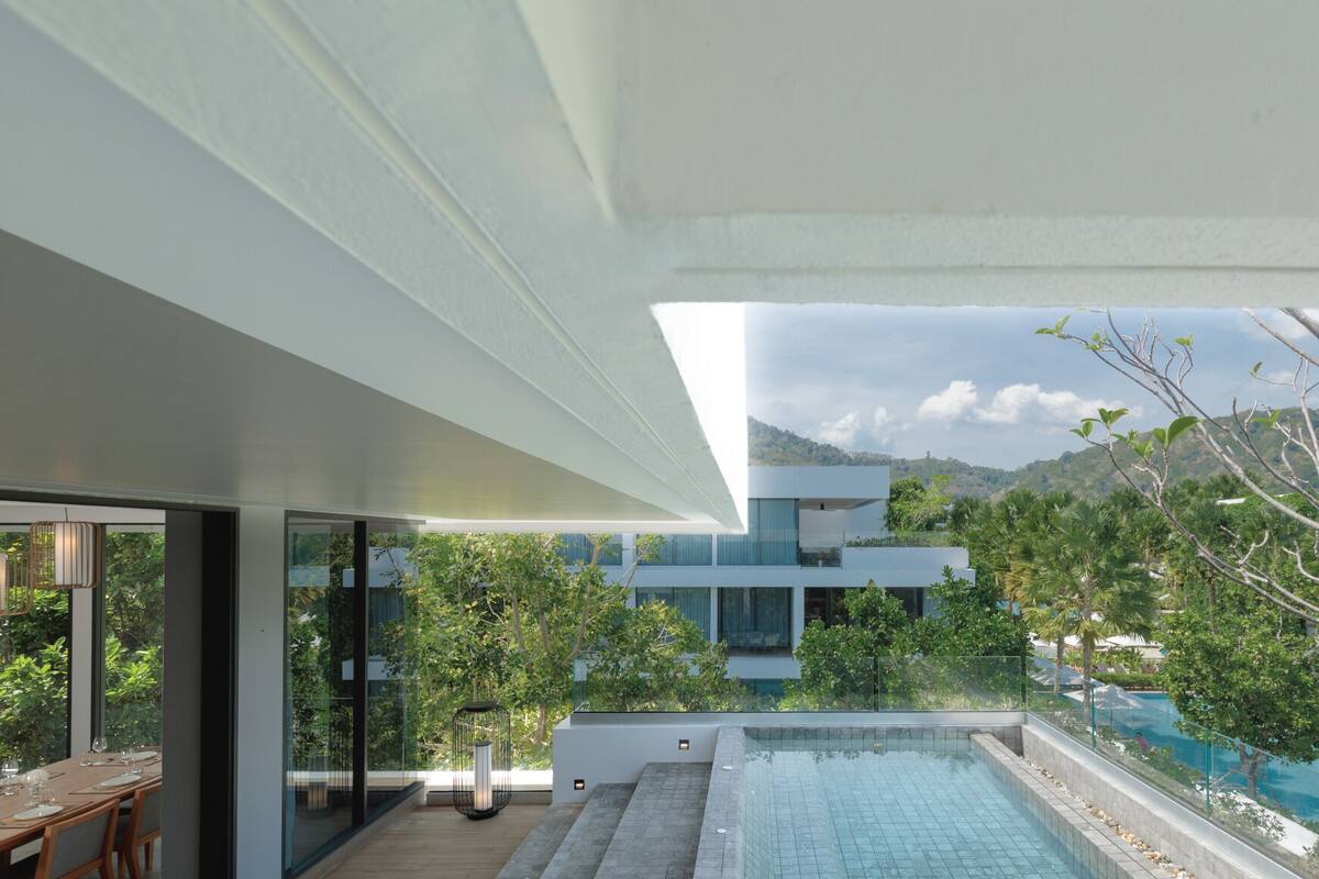 A modern outdoor pool area with a clear view of a mountain range in the background.