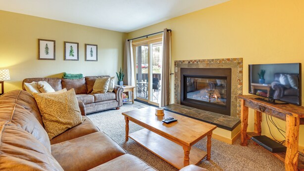 Una sala de estar con chimenea, televisor y sofá.