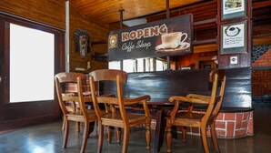 A coffee shop interior with wooden furniture and a sign reading "KOPENG Coffee Shop". - Collection O 908 Taman Wisata Kopeng (Getasan)