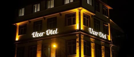 Vista frontal de la propiedad por la tarde o noche