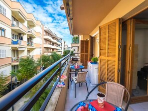 Un balcon avec une table, des chaises et une tasse à café.