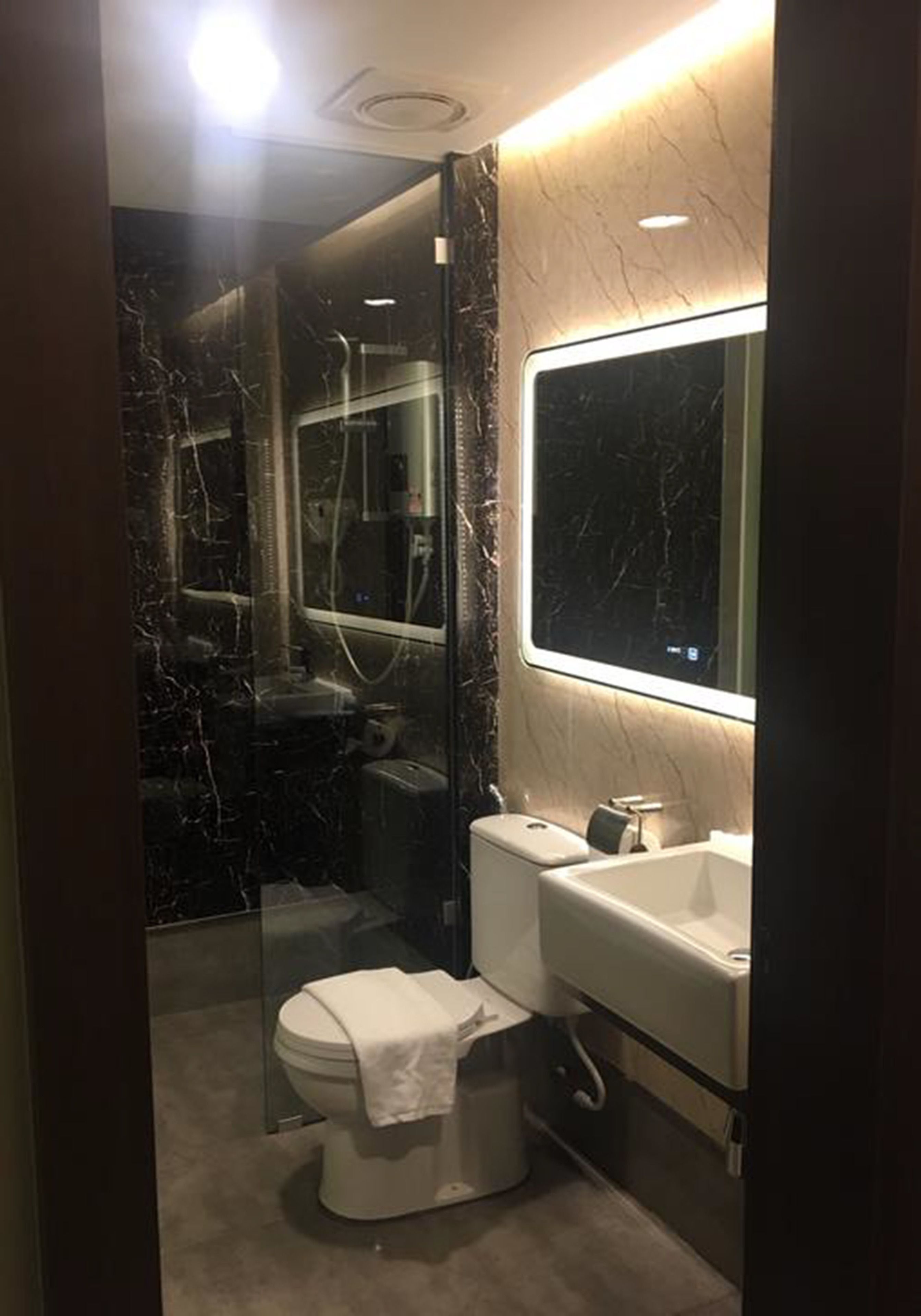 Un baño con inodoro, lavamanos y espejo.