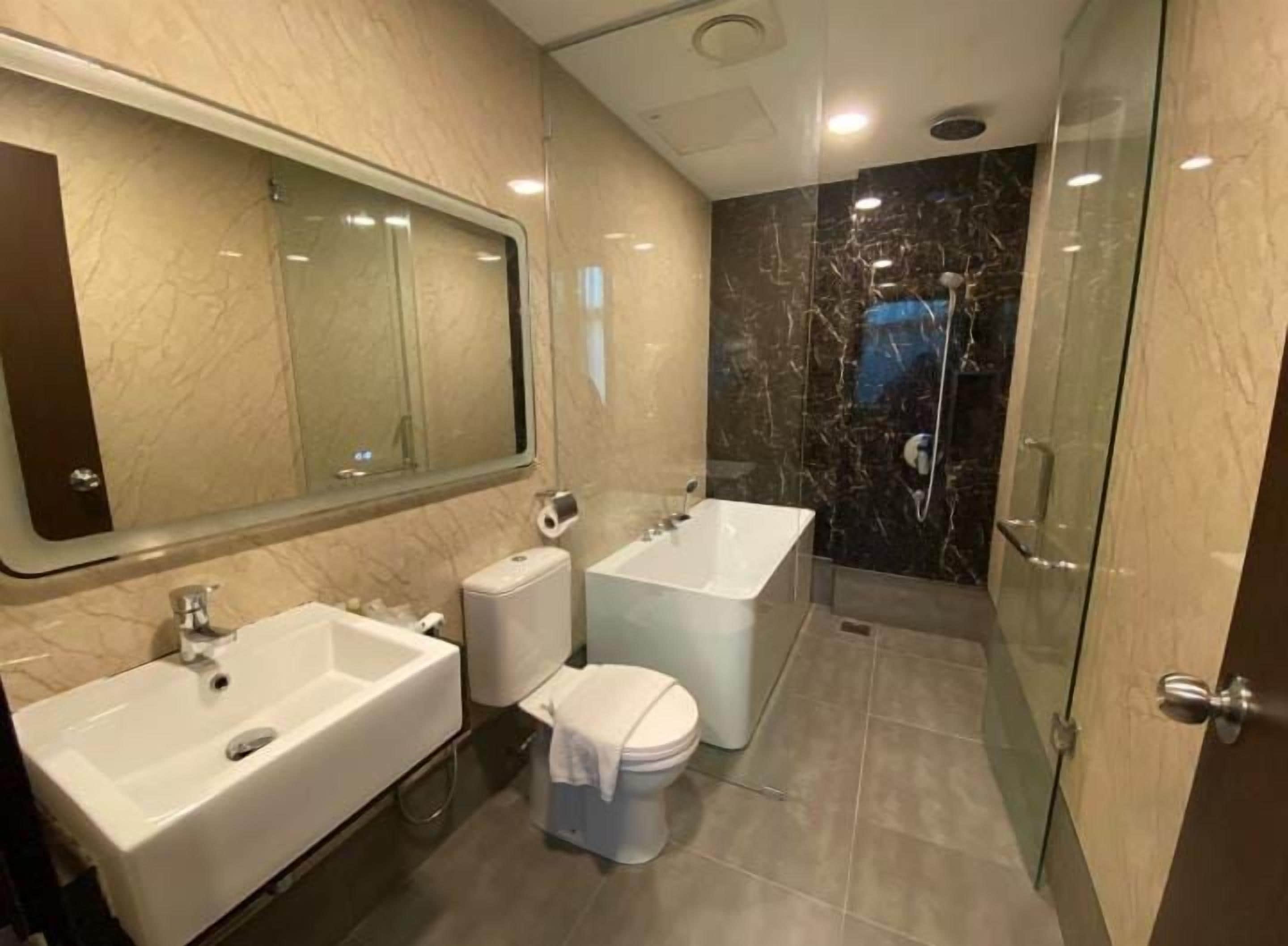 Un baño moderno con lavamanos doble, inodoro y bañera.