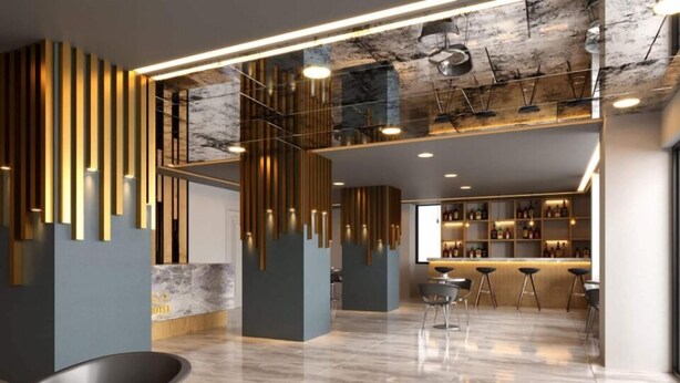 A modern interior with a bar area, seating, and a marble reception desk. - Grand Krone Hotel (Cinarcik)