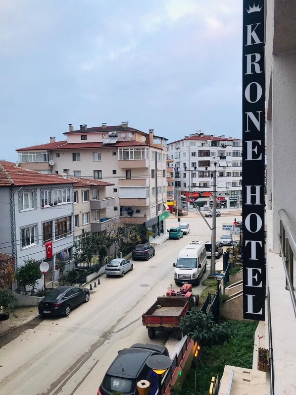 A view of a street with buildings and a hotel sign. - Grand Krone Hotel (Cinarcik)
