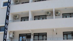 A multi-story hotel with balconies and air conditioning units. - Grand Krone Hotel (Cinarcik)