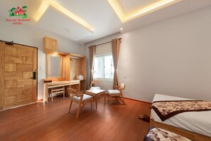 A hotel room with a wooden desk, two chairs, a bed, and a large window with curtains. - Kalaw Garden Hotel (Kalaw)