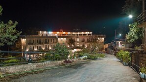 A hotel with a well-lit facade, a paved walkway, and surrounding greenery. - Kalaw Garden Hotel (Kalaw)