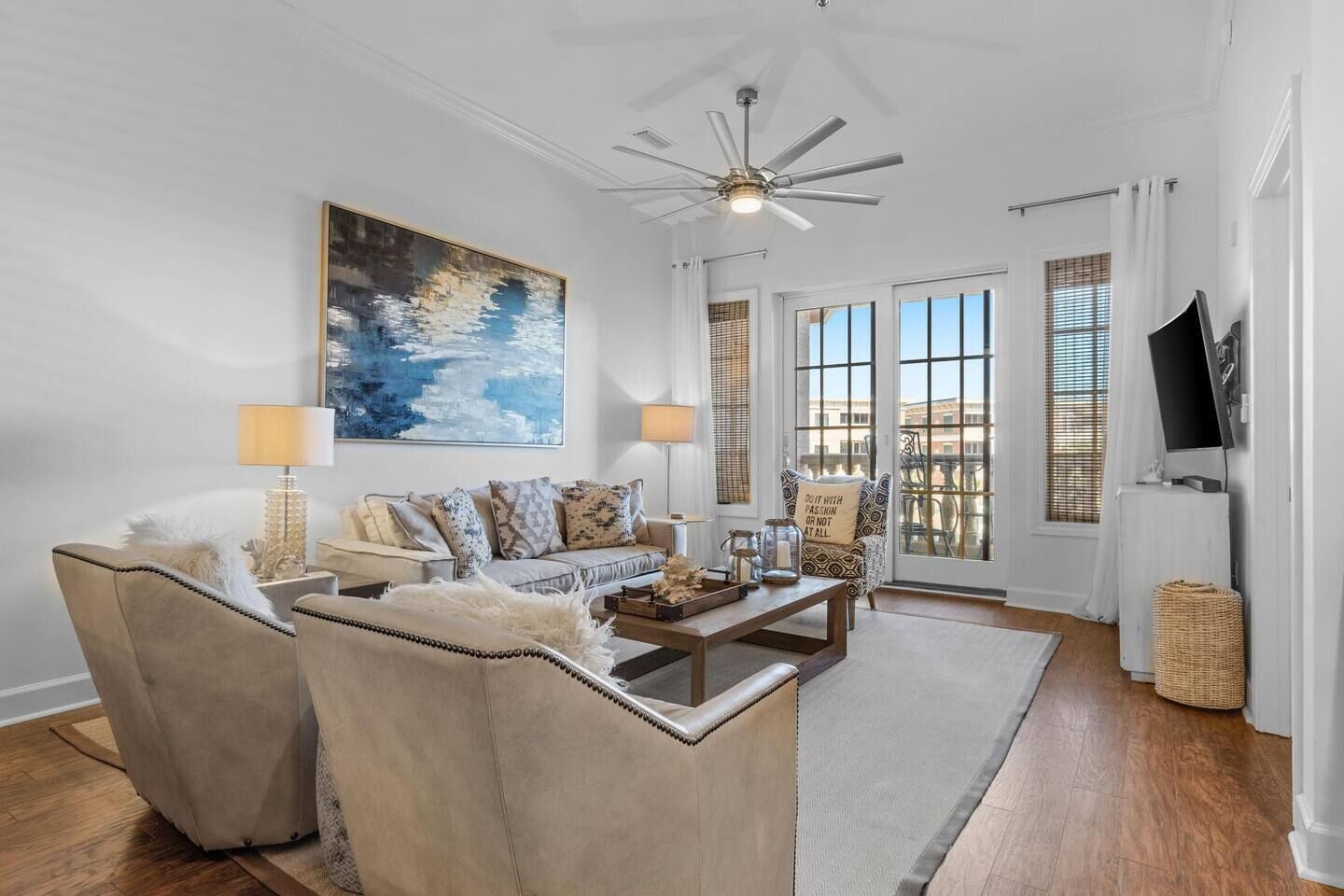 A modern living room with a sofa set, a coffee table, and a ceiling fan.