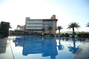 A swimming pool with a clear view of a hotel building in the background.