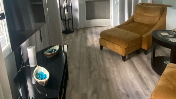 A living room with a sofa, a coffee table, a TV, and a ceiling fan. - A Gem in the Hills - Your Secret Place From Home<br> (St. Thomas)