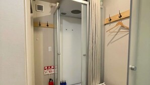 Un bagno compatto con box doccia in vetro, lavandino bianco e porta asciugamani.